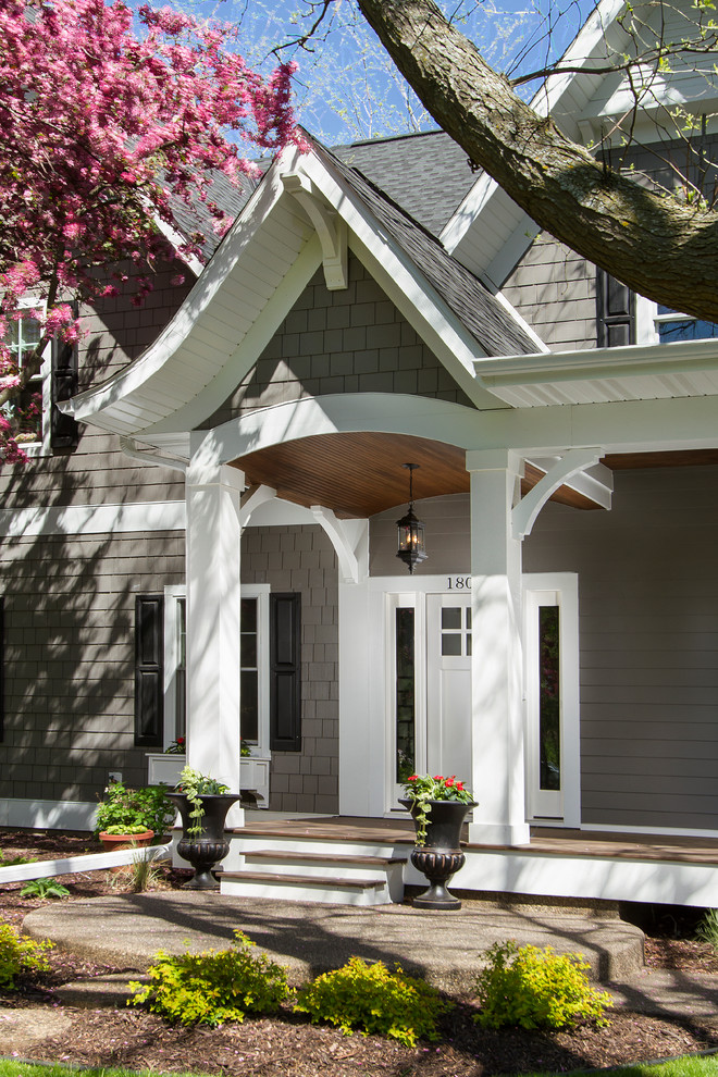 Aménagement d'une façade de maison beige classique en panneau de béton fibré de taille moyenne et à un étage avec un toit à quatre pans.