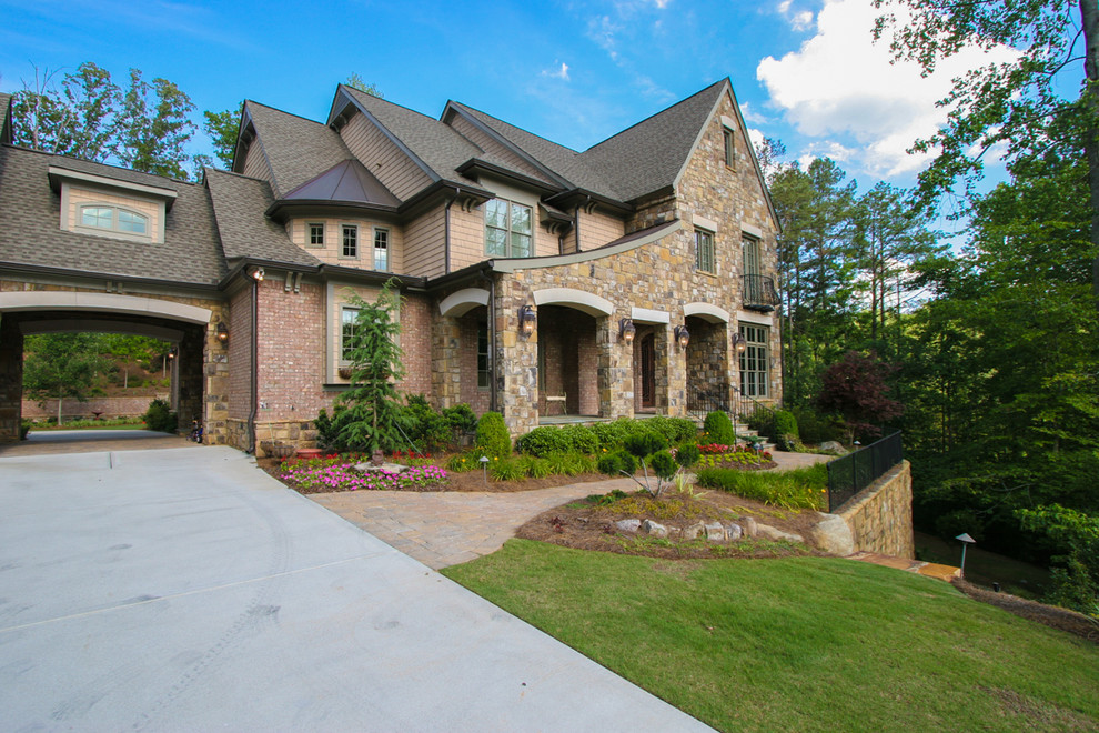 Example of a large classic beige three-story stone exterior home design in Atlanta