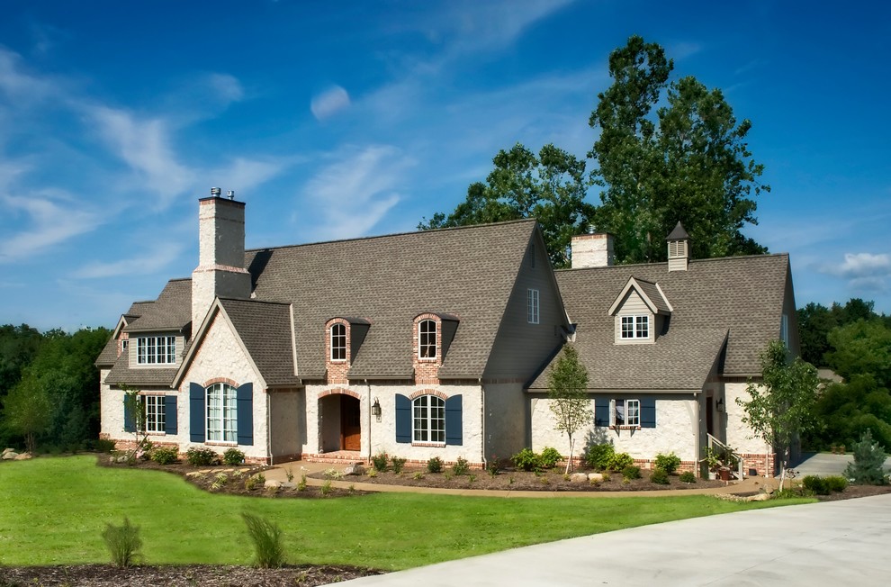 Cette photo montre une façade de maison beige chic à un étage avec un revêtement mixte, un toit à deux pans et un toit en shingle.