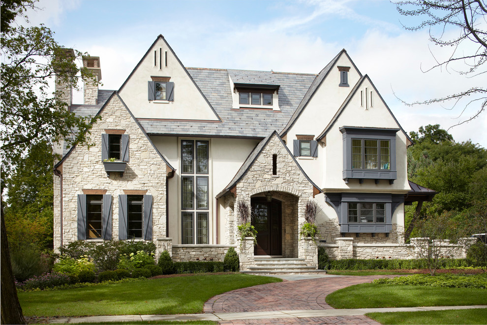French country white three-story stone exterior home idea in Chicago with a tile roof