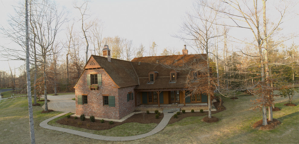 Ejemplo de fachada de casa roja clásica de tamaño medio de dos plantas con revestimiento de ladrillo, tejado a dos aguas y tejado de teja de madera