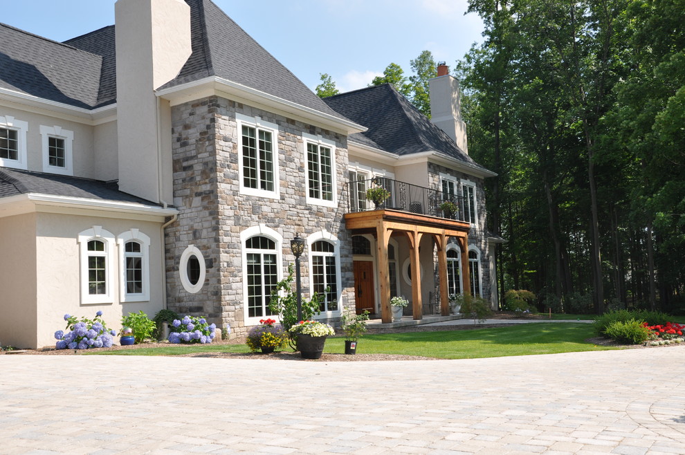 Photo of a large and yellow classic house exterior in Burlington with three floors and stone cladding.