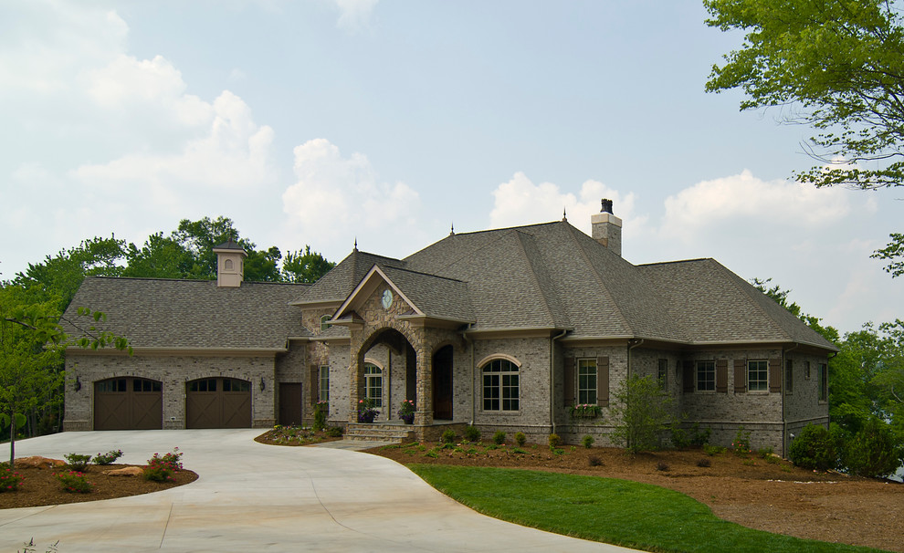 Exemple d'une façade de maison beige chic de taille moyenne et à un étage avec un revêtement mixte et un toit à deux pans.