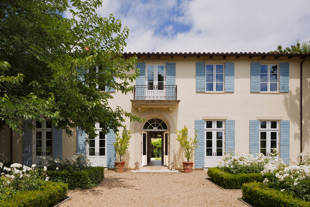Ispirazione per la villa beige a due piani con rivestimento in stucco, tetto piano e copertura in tegole