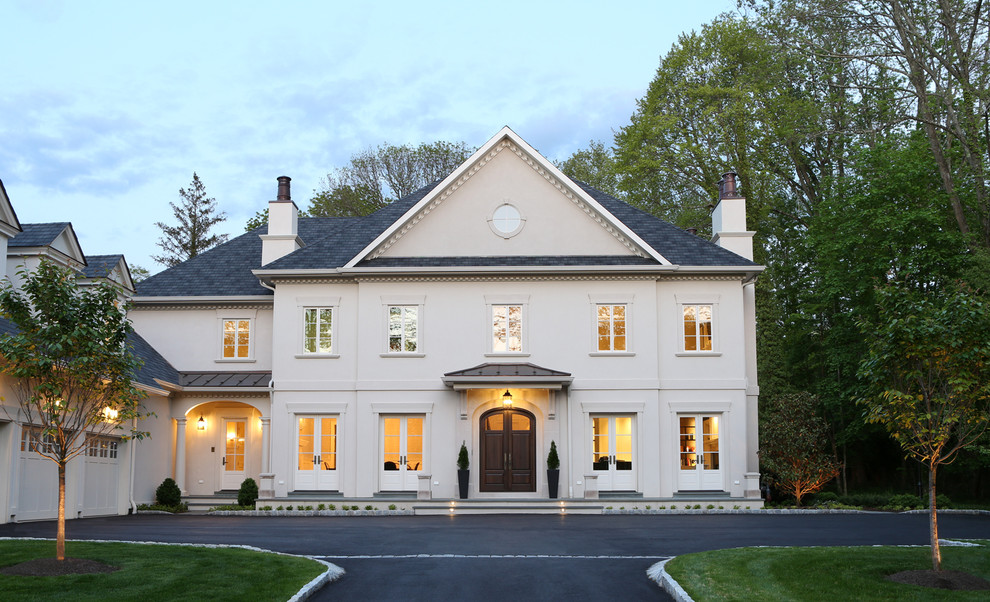 Imagen de fachada de casa beige clásica grande de tres plantas con revestimiento de estuco, tejado a cuatro aguas y tejado de teja de madera