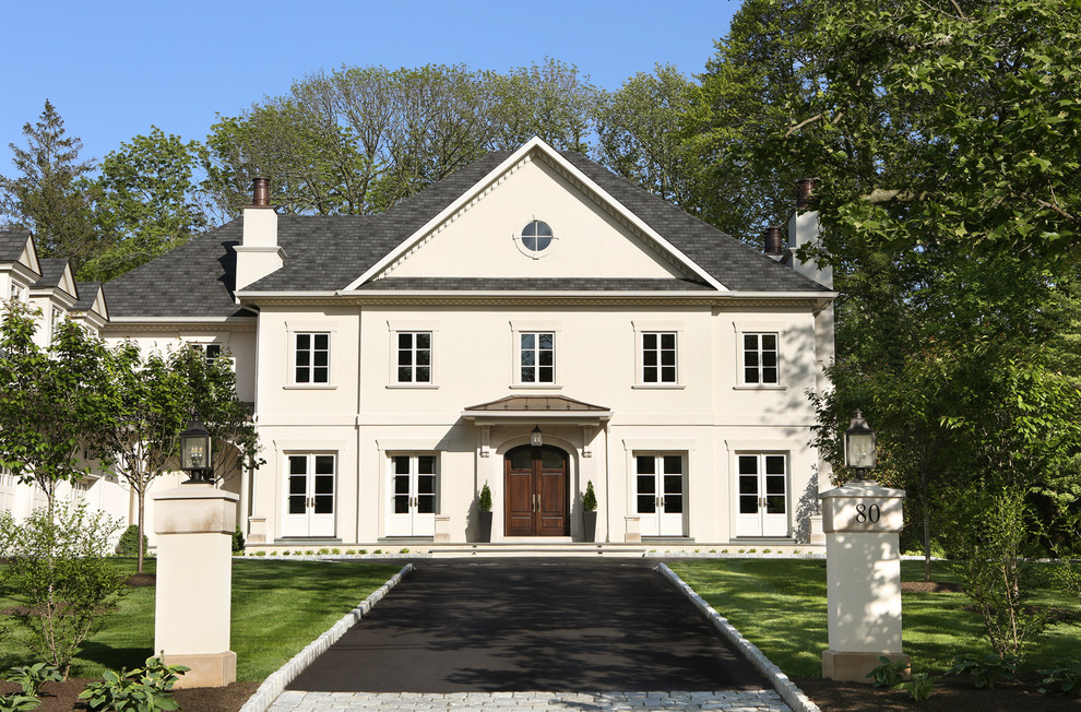 Idee per la villa grande beige classica a tre piani con rivestimento in stucco e tetto a padiglione