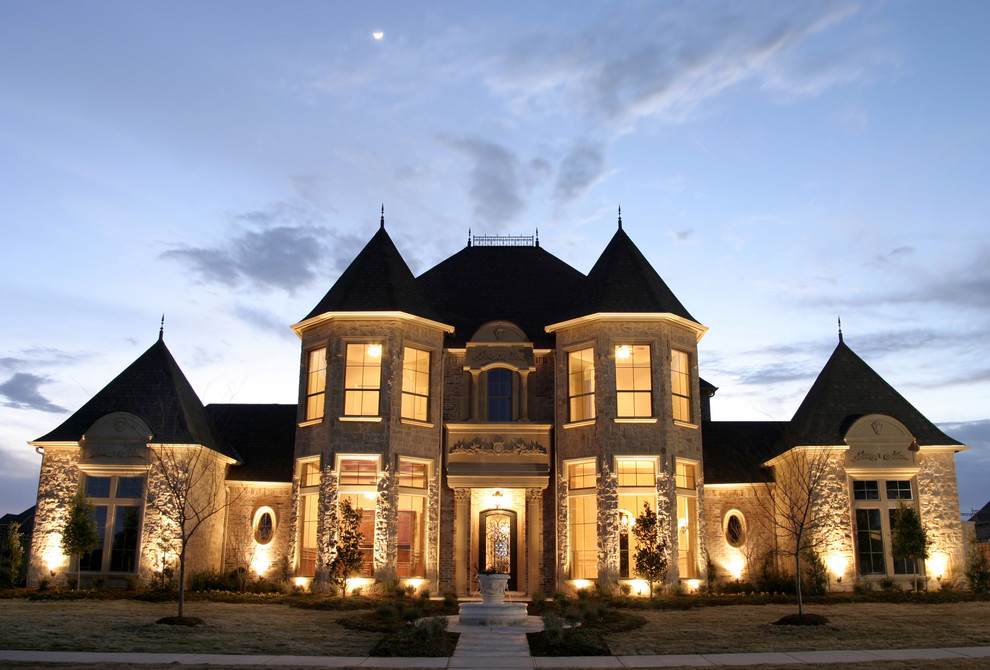 Immagine della facciata di una casa grande beige classica a due piani con rivestimento in pietra