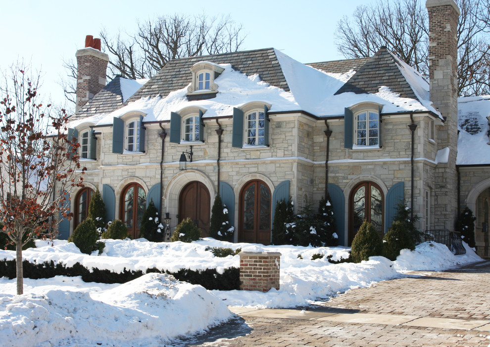 Foto della facciata di una casa grande beige classica a due piani con rivestimento in pietra