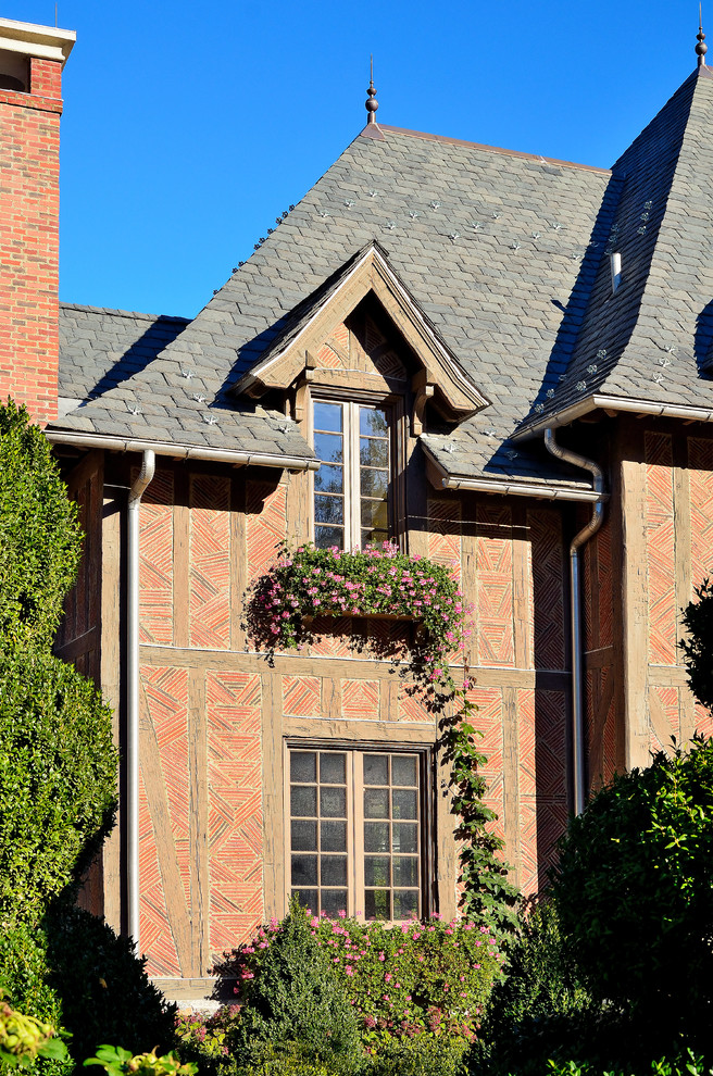 Inspiration pour une façade de maison rouge traditionnelle en brique à deux étages et plus avec un toit à quatre pans.