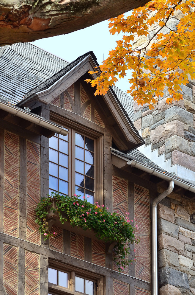 This is an example of a red traditional brick house exterior in New York with a hip roof and three floors.