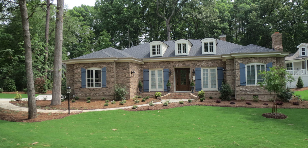Inspiration for a large rustic one-story brick house exterior remodel in Raleigh with a hip roof and a shingle roof