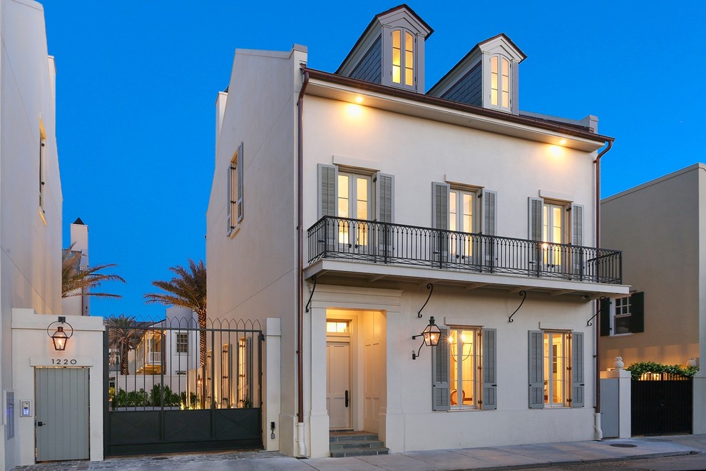 Cette photo montre une grande façade de maison blanche chic en stuc à deux étages et plus avec un toit en shingle.