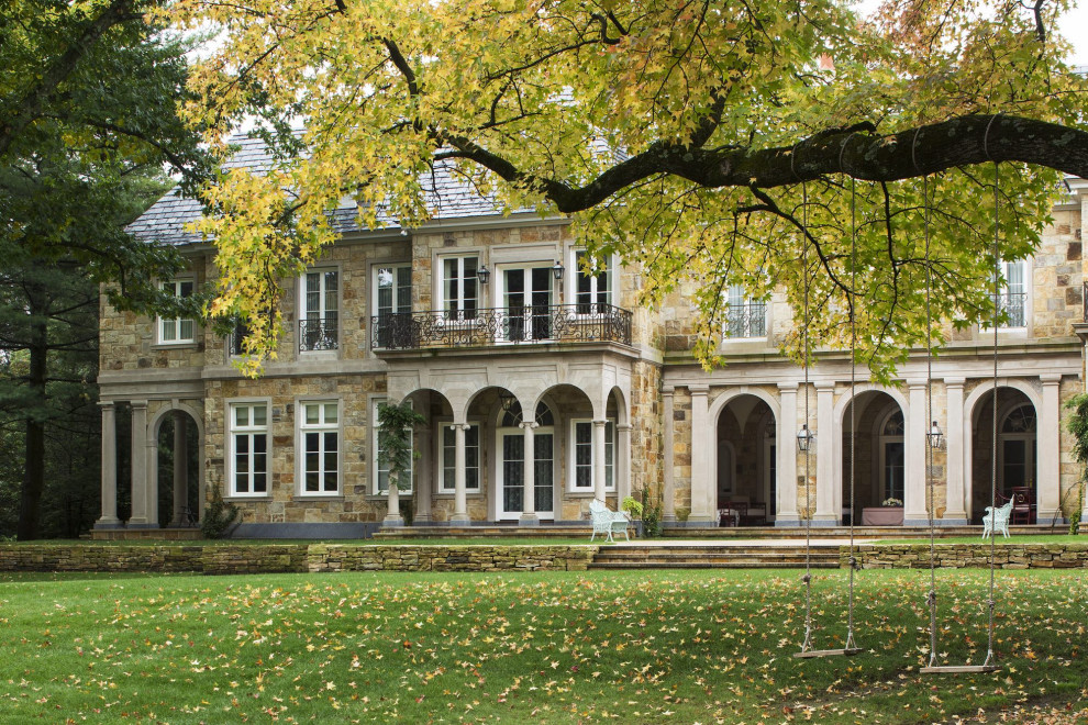 Idée de décoration pour une très grande façade de maison beige tradition en pierre à deux étages et plus avec un toit en tuile.