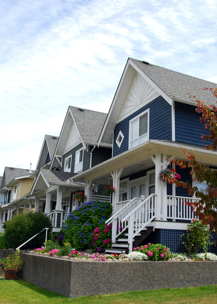 This is an example of a medium sized and blue traditional two floor detached house in Vancouver with mixed cladding, a pitched roof and a shingle roof.