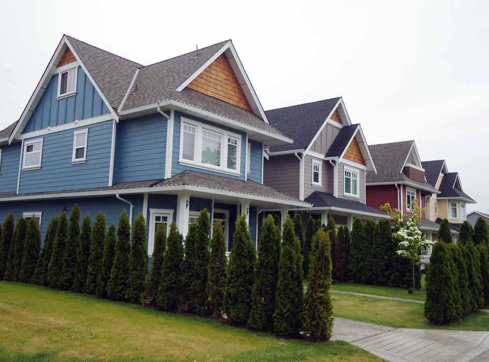 Ejemplo de fachada de casa azul clásica de tamaño medio de dos plantas con revestimientos combinados, tejado a dos aguas y tejado de teja de madera