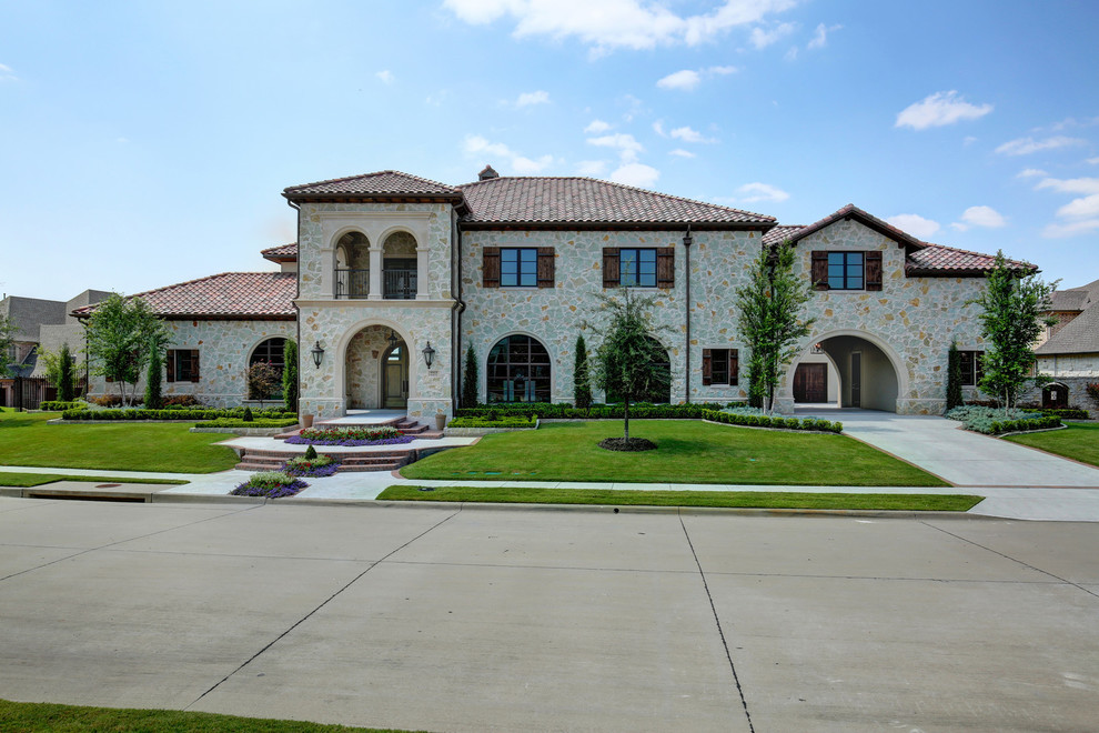This is an example of a large and white mediterranean two floor detached house in Dallas with a tiled roof.