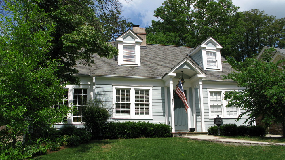 Immagine della facciata di una casa blu classica a due piani con rivestimento con lastre in cemento e tetto a capanna