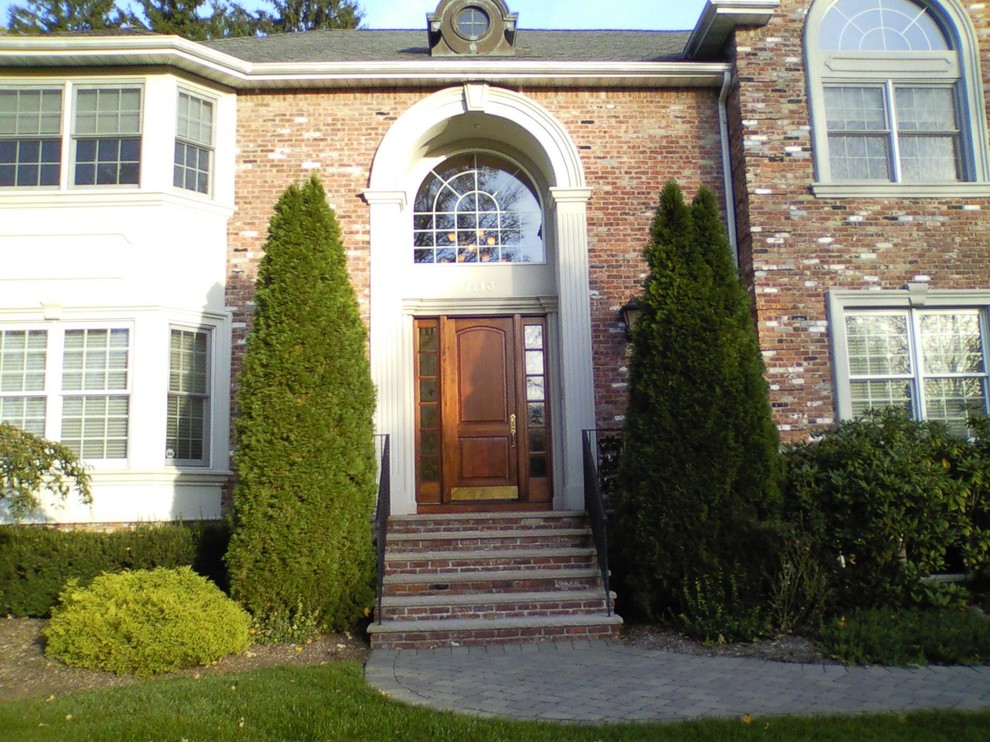 Example of a large classic brown two-story brick gable roof design in Newark