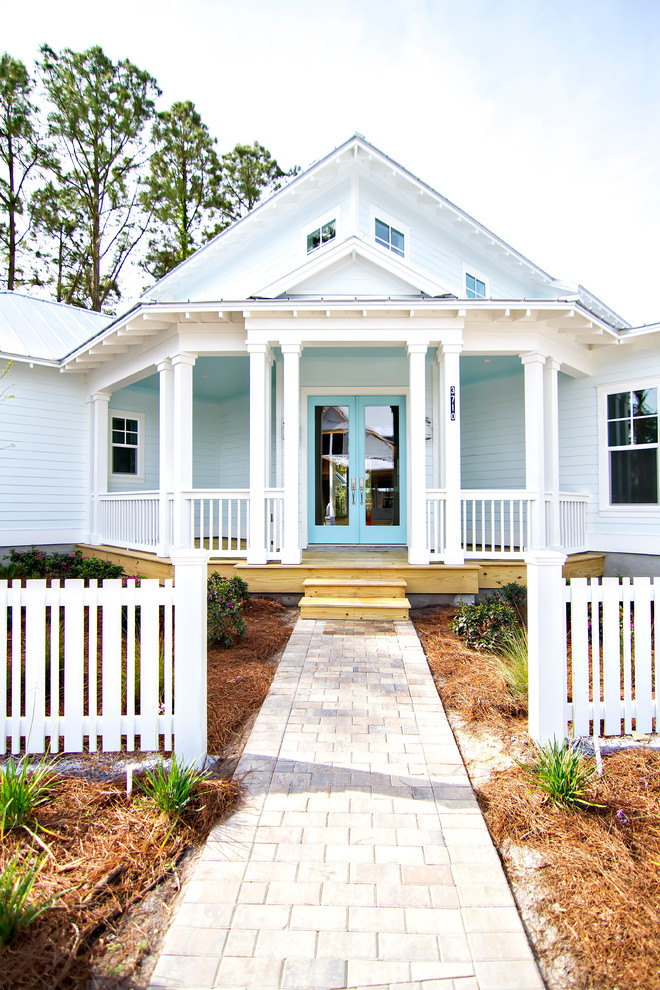 Стильный дизайн: двухэтажный, деревянный, синий частный загородный дом среднего размера в морском стиле с двускатной крышей и металлической крышей - последний тренд