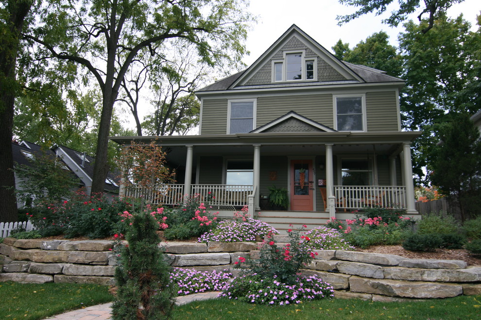 Cette image montre une façade de maison verte traditionnelle de taille moyenne et à deux étages et plus avec un revêtement en vinyle, un toit à deux pans et un toit en shingle.