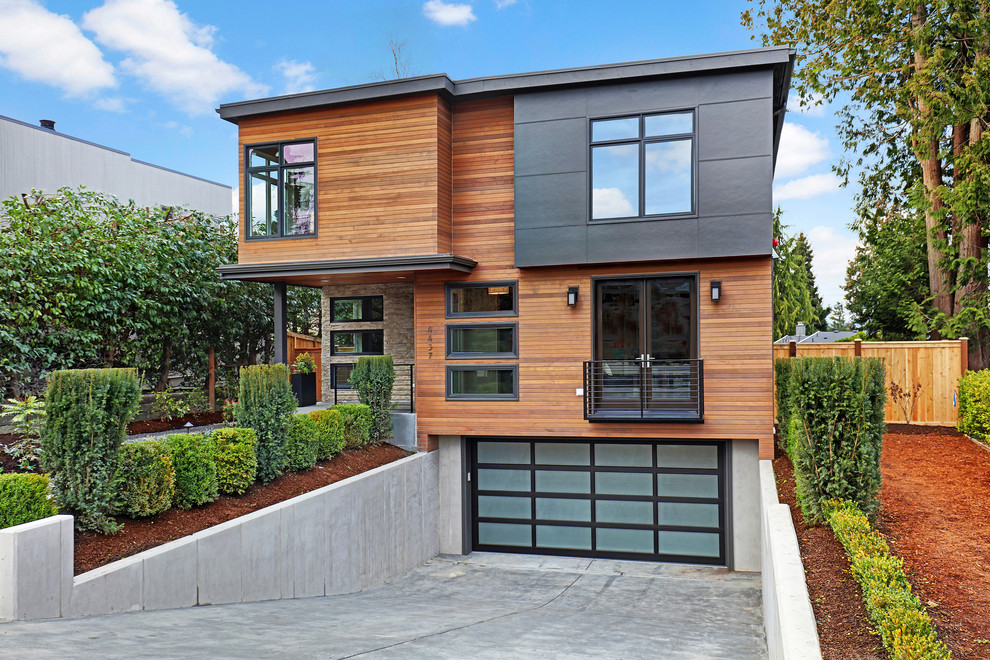 This is an example of a gey contemporary house exterior in Seattle with three floors, mixed cladding and a flat roof.