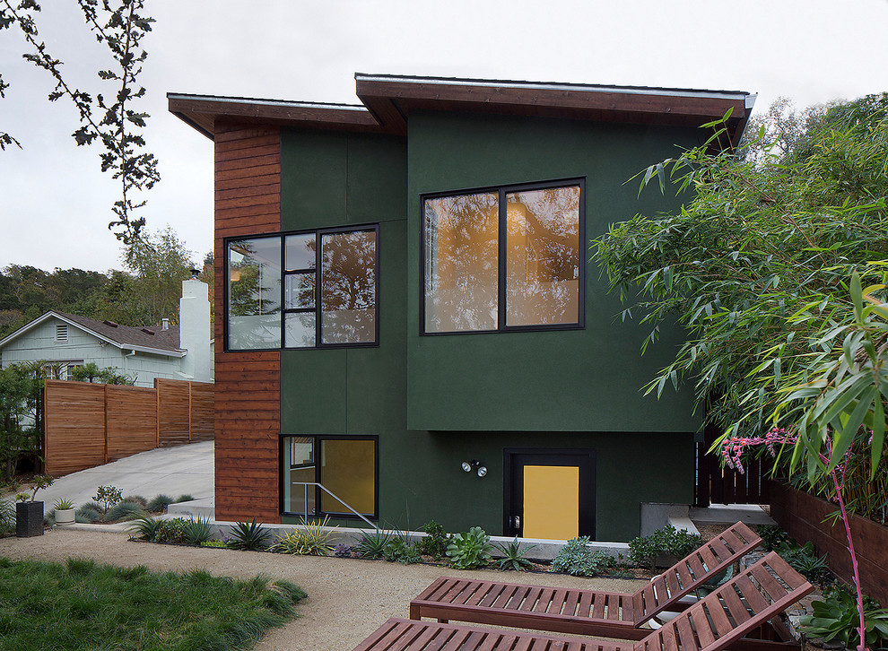 Exemple d'une façade de maison verte moderne en stuc de taille moyenne et de plain-pied avec un toit en appentis.
