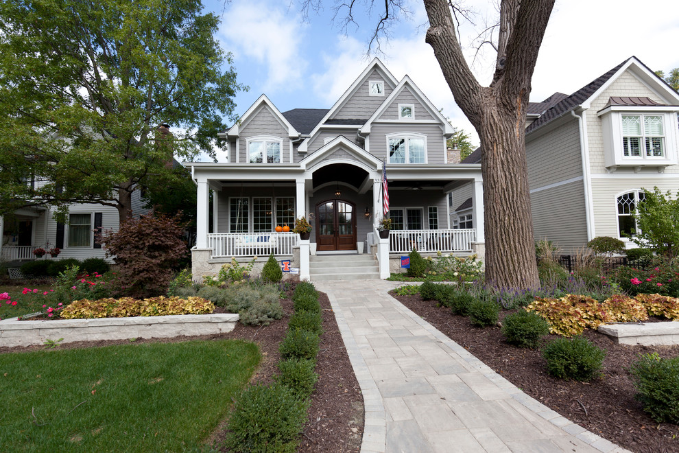 Mittelgroßes, Zweistöckiges Landhaus Einfamilienhaus mit Vinylfassade, grauer Fassadenfarbe, Satteldach und Schindeldach in Chicago