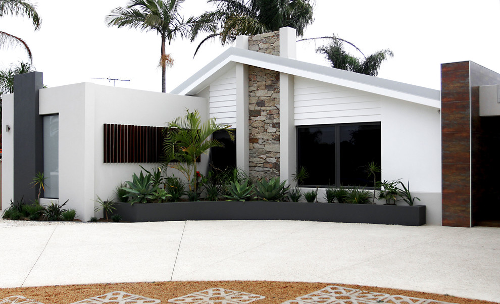 This is an example of a large and white midcentury bungalow house exterior in Perth with a pitched roof.