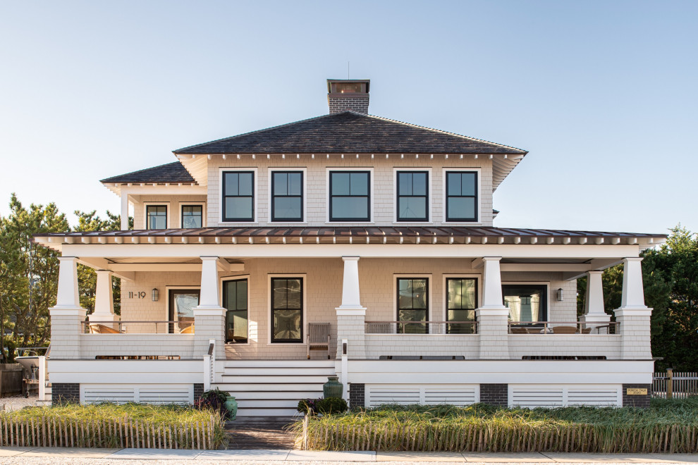 Ispirazione per la villa beige a due piani di medie dimensioni con rivestimento in legno, tetto a padiglione, copertura a scandole, con scandole e tetto nero