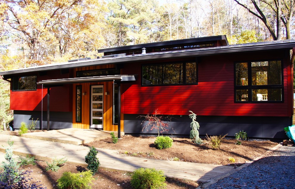 Foto de fachada roja contemporánea de una planta con revestimiento de madera y tejado plano