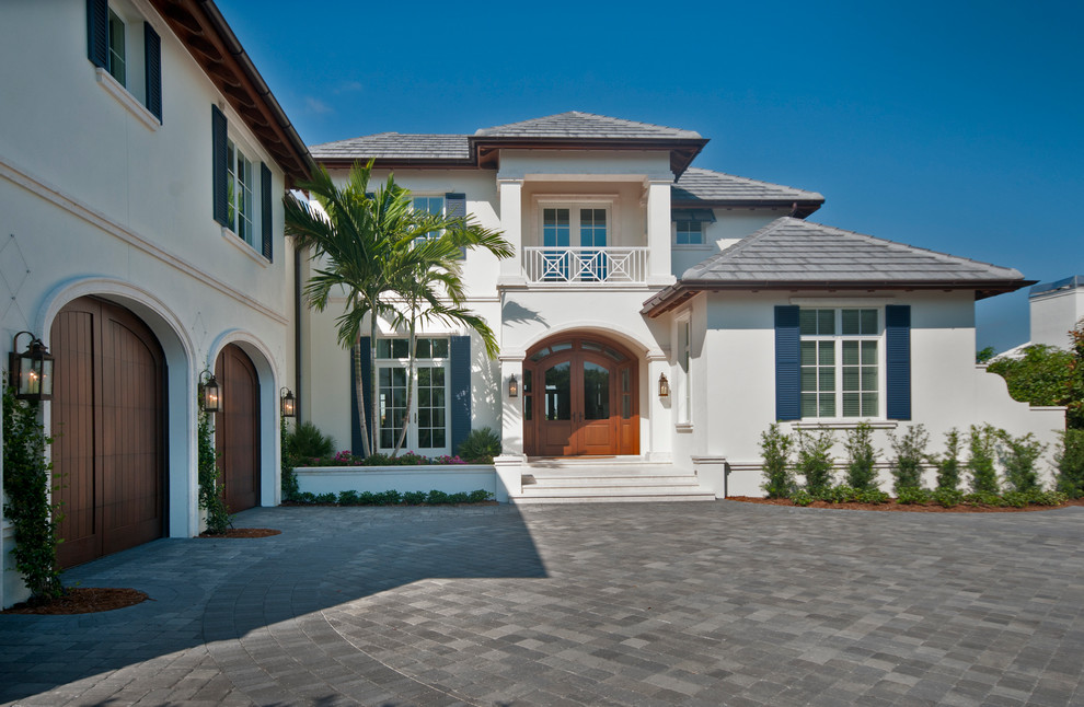 Example of a tuscan beige two-story exterior home design in Miami with a hip roof