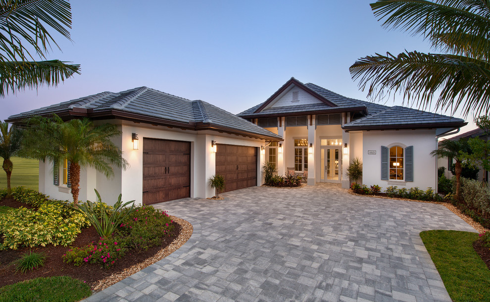 Large island style gray one-story stucco gable roof photo in Tampa