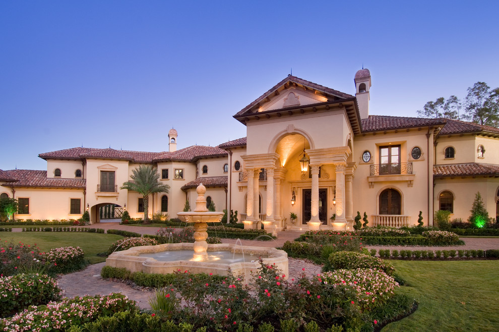 Huge traditional beige two-story stucco house exterior idea in Houston