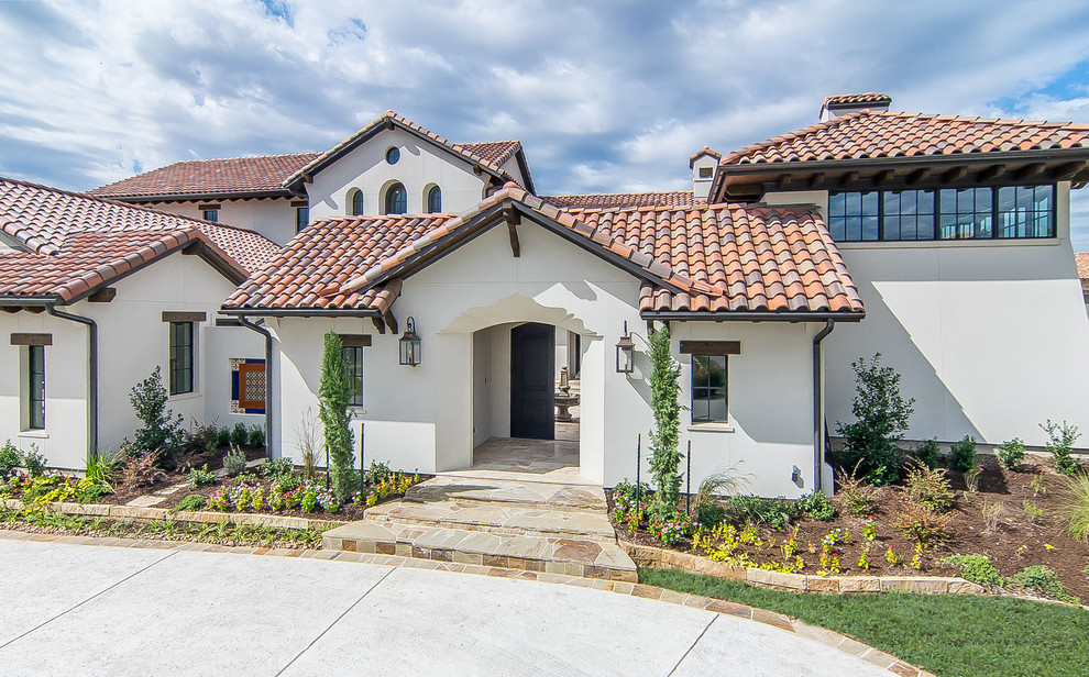 Inspiration for a large mediterranean white two-story stucco exterior home remodel in Dallas with a tile roof