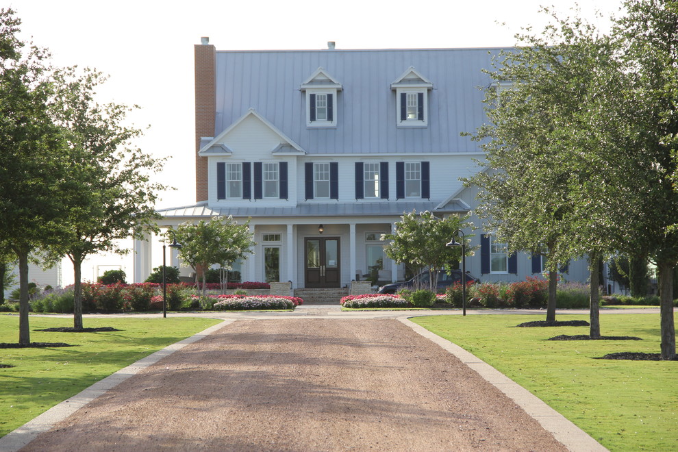 Foto della facciata di una casa ampia bianca country a tre piani con rivestimento in legno e tetto a capanna