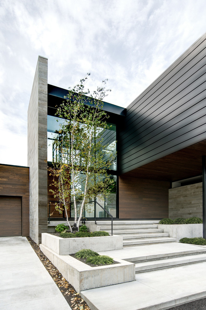 Ejemplo de fachada de casa actual de dos plantas con revestimientos combinados y tejado plano