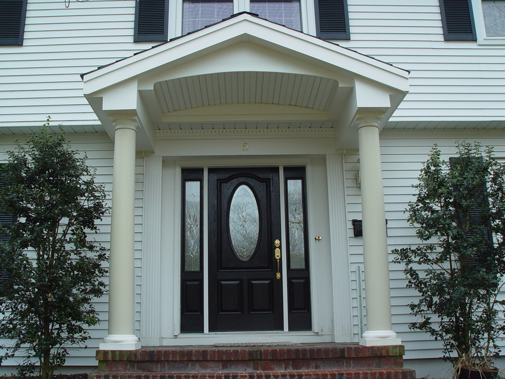 Immagine della facciata di una casa grande bianca classica a due piani con rivestimento in vinile e tetto a capanna