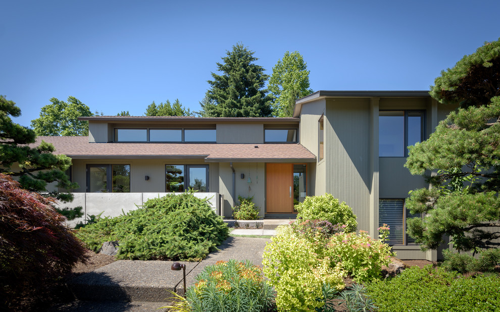 Ejemplo de fachada de casa beige moderna de tamaño medio a niveles con revestimiento de madera y tejado de teja de madera