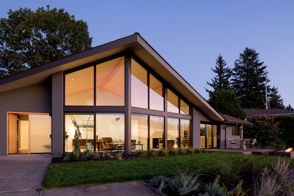Diseño de fachada de casa gris retro de tamaño medio de dos plantas con revestimiento de ladrillo, tejado a cuatro aguas y tejado de teja de madera