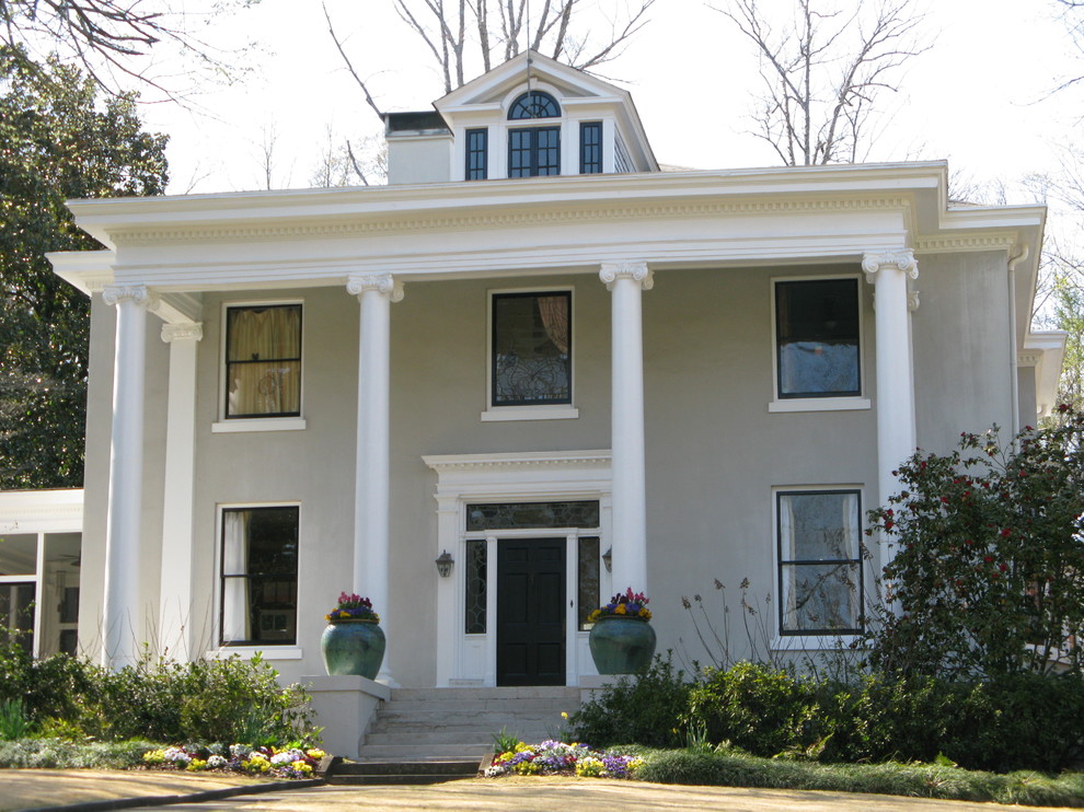 This is an example of a gey and expansive classic render house exterior in Atlanta with three floors.
