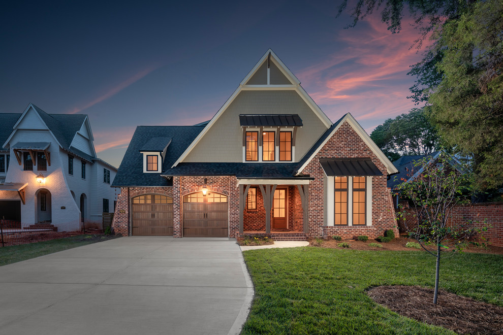 Inspiration for a large transitional green two-story brick exterior home remodel in Charlotte with a shingle roof