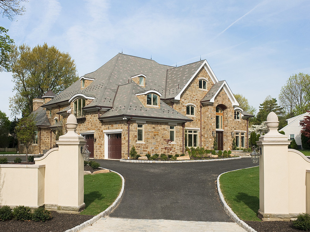 Large traditional beige three-story stone exterior home idea in Philadelphia with a hip roof