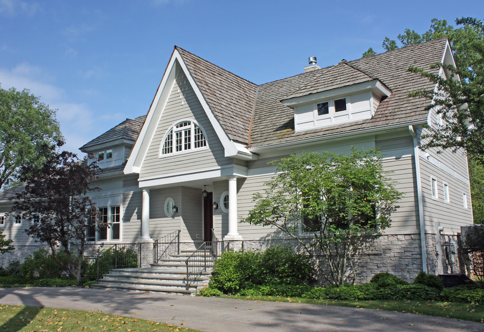 Foto della facciata di una casa beige classica a due piani con rivestimento con lastre in cemento