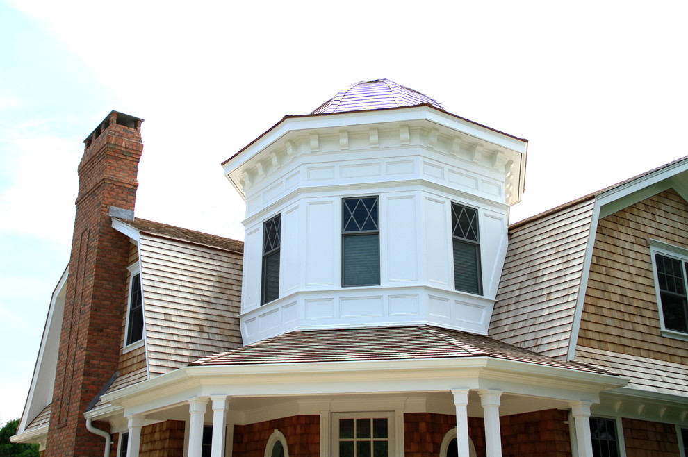 Example of a large beach style brown two-story wood house exterior design in New York with a shingle roof
