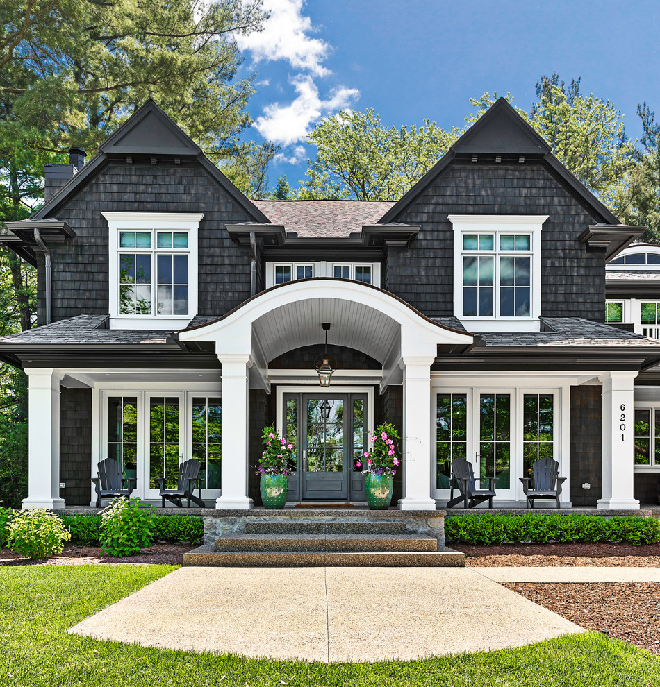 Large beach style black two-story wood exterior home photo in Detroit with a shingle roof
