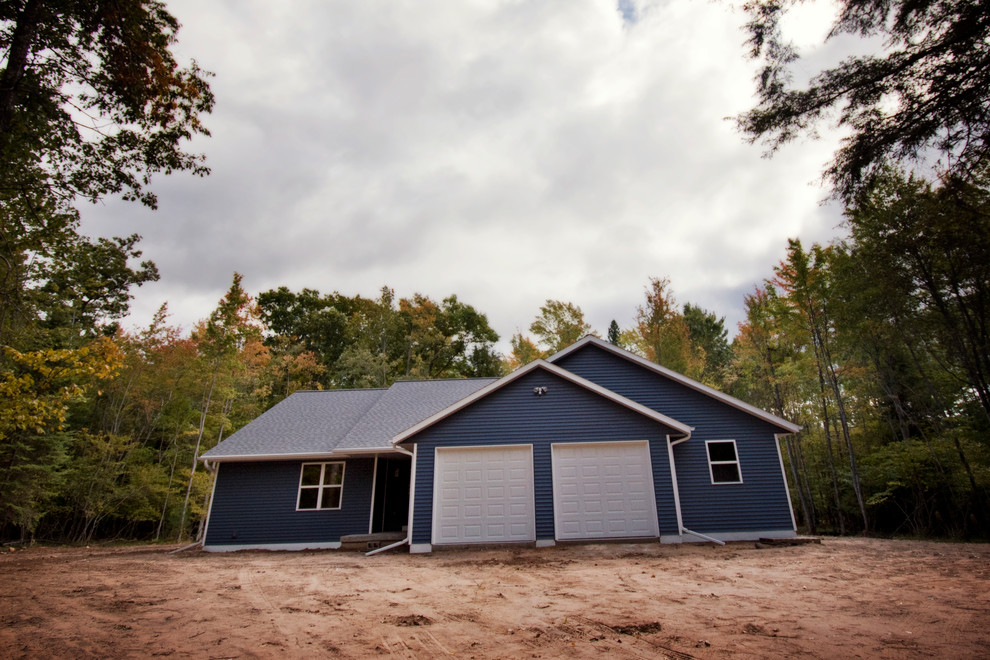 Ejemplo de fachada de casa azul rural de tamaño medio de una planta con revestimiento de vinilo y tejado de teja de madera