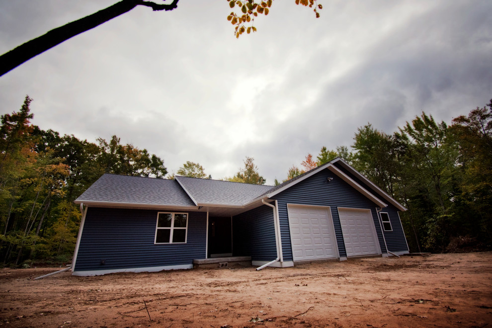 Diseño de fachada de casa azul rural de tamaño medio de una planta con revestimiento de vinilo y tejado de teja de madera