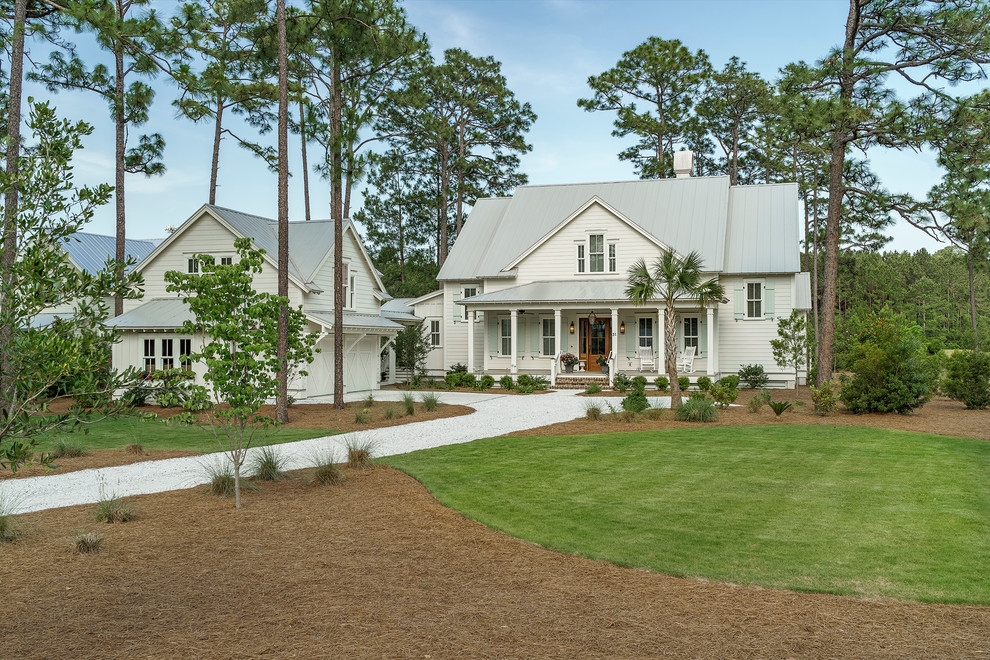 Imagen de fachada blanca clásica renovada grande de dos plantas con revestimiento de madera, tejado a dos aguas y tejado de metal