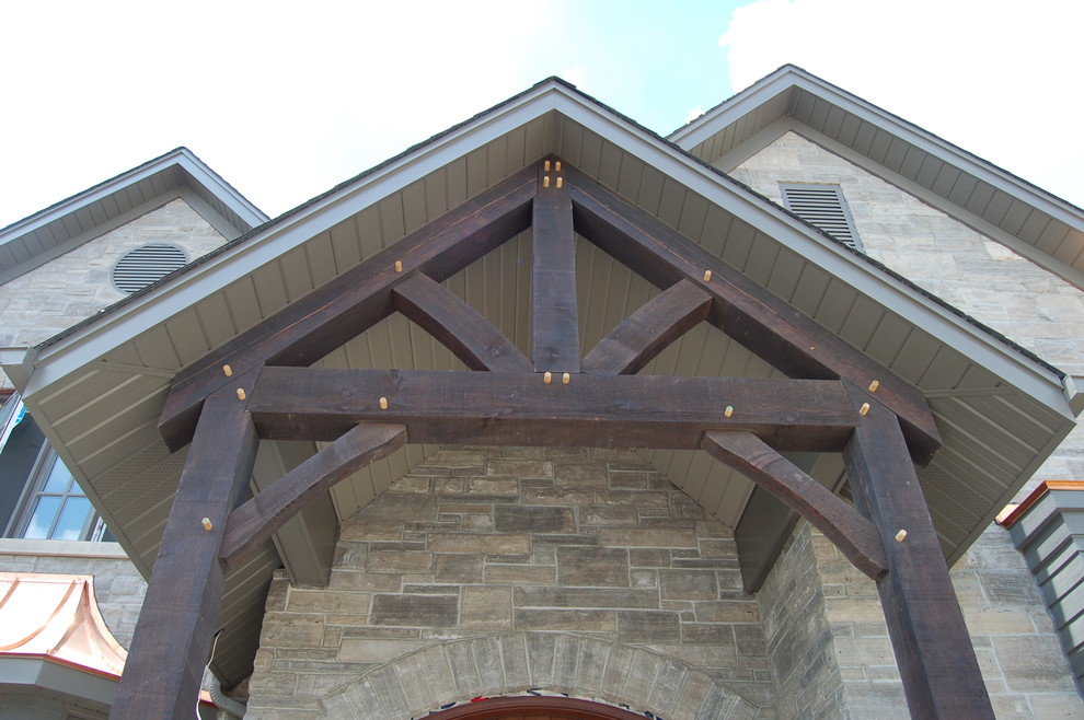 Idées déco pour une grande façade de maison beige classique en pierre à un étage avec un toit à deux pans.