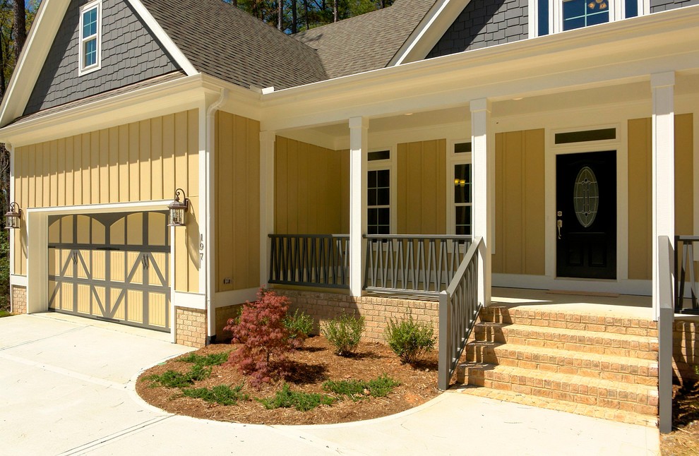 Idée de décoration pour une façade de maison jaune tradition de taille moyenne et à un étage avec un revêtement mixte.